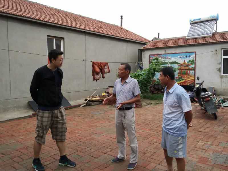 指导教师张建峰与村长了解村里情况.jpg